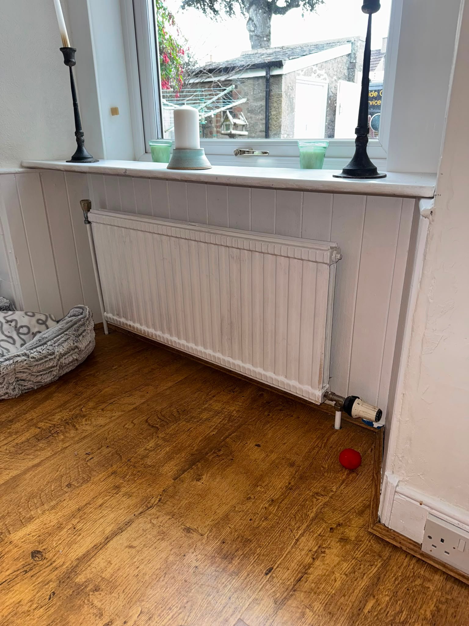 Old radiator beneath window before replacement